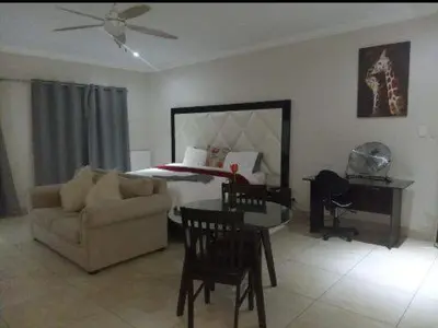 a living room with a couch and a bed at Mountvista Guesthouse in Pretoria