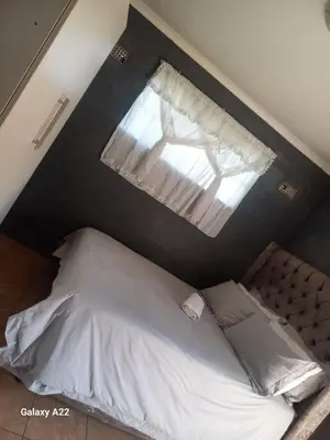 a bedroom with a large bed with a window at comfort zone in Kempton Park