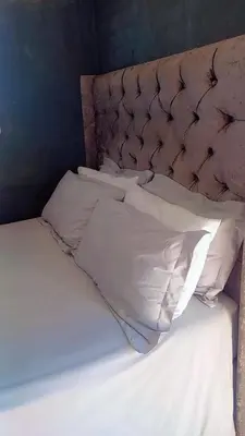 an unmade bed with white sheets and pillows at comfort zone in Kempton Park