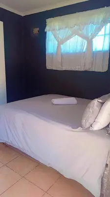 a bed in a room with a window at comfort zone in Kempton Park