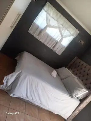 a bed in a room with a window at comfort zone in Kempton Park