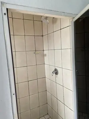 a bathroom with a shower with white tiles at comfort zone in Kempton Park