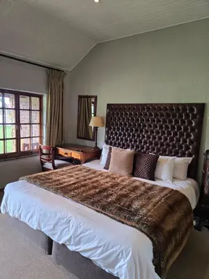 a bedroom with a large bed with a large headboard at Lakeside 12 in Dullstroom