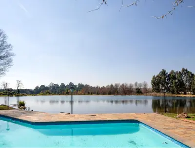 an empty swimming pool in front of a lake at Lakeside 12 in Dullstroom