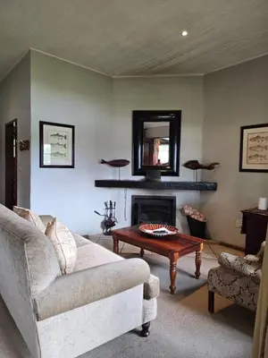 a living room with a couch and a fireplace at Lakeside 12 in Dullstroom