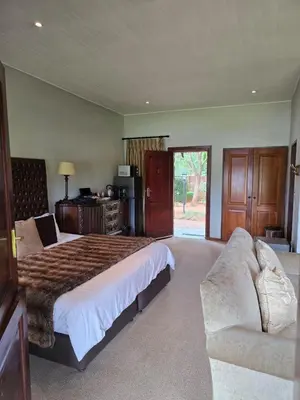 a bedroom with a large bed and a couch at Lakeside 12 in Dullstroom