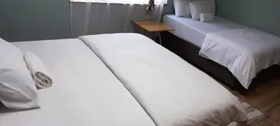 two white beds in a room with a window at Majestic Guest House in Mokopane