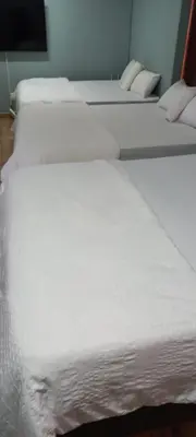 a row of white beds in a room at Majestic Guest House in Mokopane