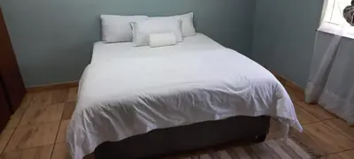 a large white bed with white sheets and pillows at Majestic Guest House in Mokopane