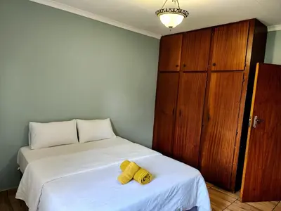 a bedroom with a bed with a yellow stuffed animal on it at Majestic Guest House in Mokopane