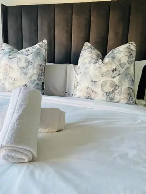 a white bed with pillows and a towel on it at 1 bedroom- The Blyde by Given in Pretoria