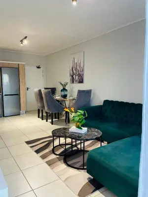a living room with a green couch and a table at 1 bedroom- The Blyde by Given in Pretoria