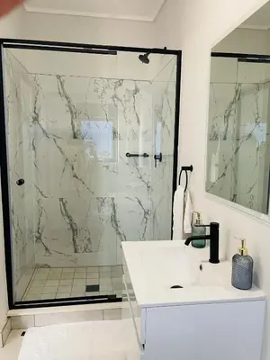 a bathroom with a shower and a white sink at 1 bedroom- The Blyde by Given in Pretoria
