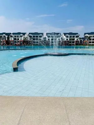 a fountain in the middle of a pool with buildings at 1 bedroom- The Blyde by Given in Pretoria