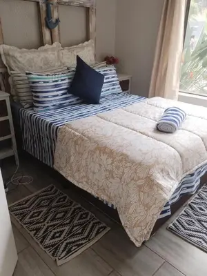 a bedroom with a bed with pillows on it at casa bella in Hartbeespoort