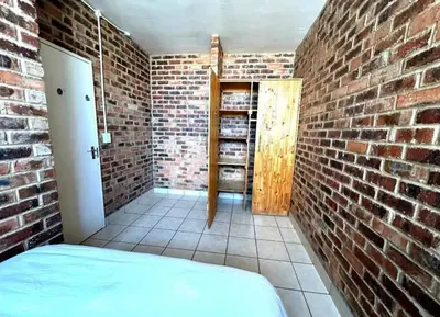 a brick room with a bed in a brick wall at Kwamathebula in Benoni