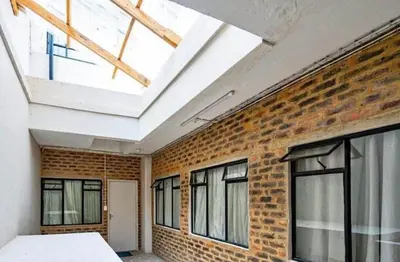 a room with a brick wall and a skylight at Kwamathebula in Benoni