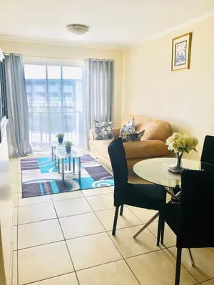 a living room with a couch and a table at Menlyn Comfort Place in Pretoria