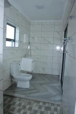 a white bathroom with a toilet and a shower at Alldays Sunset Lodge in Alldays