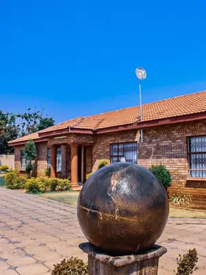 a large metal ball sitting in front of a building at Alldays Sunset Lodge in Alldays