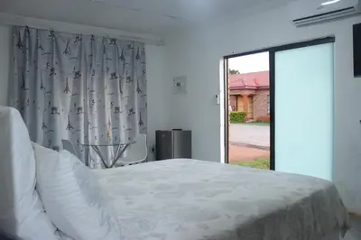 a bedroom with a bed and a large window at Alldays Sunset Lodge in Alldays