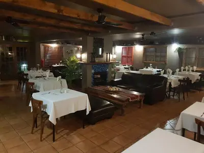 a dining room with tables and chairs and a restaurant at The Gateway Inn in Louis Trichardt