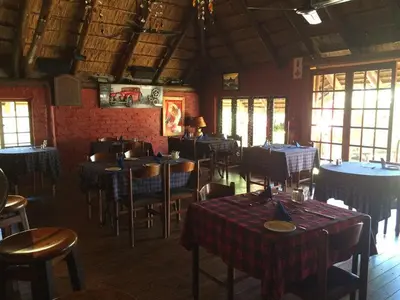 a dining room with tables and chairs in a restaurant at The Gateway Inn in Louis Trichardt