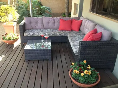 a patio with a couch and a table and flowers at The Gateway Inn in Louis Trichardt