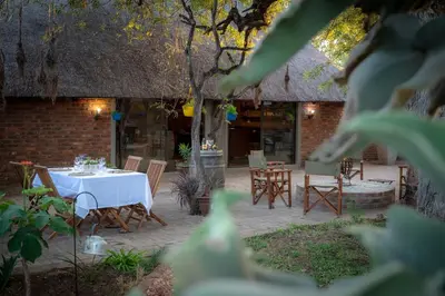 a patio with a table and chairs and a building at Ngoma Bush Lodge in Hoedspruit