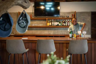 a man sitting at a bar in a restaurant at Ngoma Bush Lodge in Hoedspruit