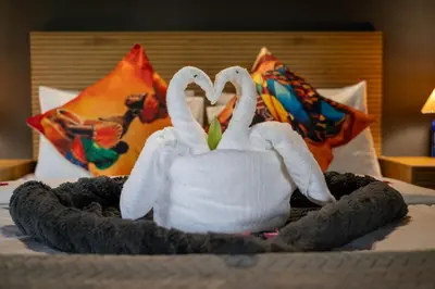two stuffed swans making a heart shape on a bed at Ngoma Bush Lodge in Hoedspruit