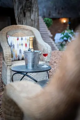 a table with a bottle of wine and a glass at Ngoma Bush Lodge in Hoedspruit