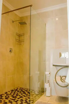 a bathroom with a glass shower with a toilet at Serenity in Hartbeespoort