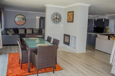 a living room with a table and chairs and a couch at Serenity in Hartbeespoort