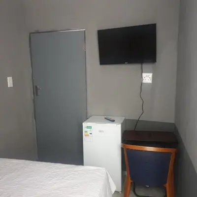 a small room with a refrigerator and a television at Muhle Guesthouse in Giyani