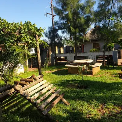 a wooden bench in a yard with a table at Muhle Guesthouse in Giyani