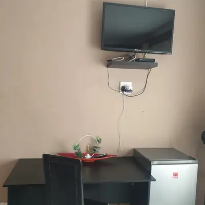 a desk with a television on a wall with a toy on it at Muhle Guesthouse in Giyani