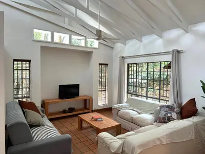 a living room with two couches and a tv at Three on Taurus in Nelspruit