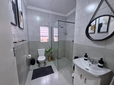 a bathroom with a toilet and a shower and a sink at Nightingale Lodge Bed and Breakfast in Kempton Park