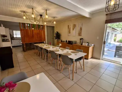a dining room with a long table and chairs at Nightingale Lodge Bed and Breakfast in Kempton Park