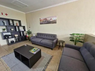 a living room with two couches and a coffee table at Nightingale Lodge Bed and Breakfast in Kempton Park