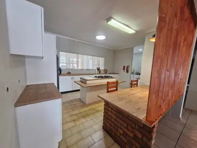 a kitchen with white cabinets and a wooden counter top at Nightingale Lodge Bed and Breakfast in Kempton Park