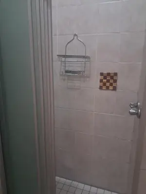 a bathroom with a shower with a tile wall at Menlyn Place Cityscape in Pretoria