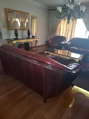 a living room with a leather couch and a table at The Adress in Midrand