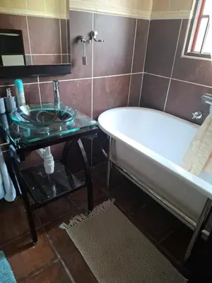 a bathroom with a bath tub and a sink at The Adress in Midrand