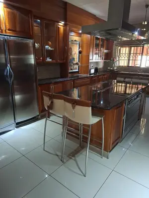 a kitchen with wooden cabinets and stainless steel appliances at The Adress in Midrand