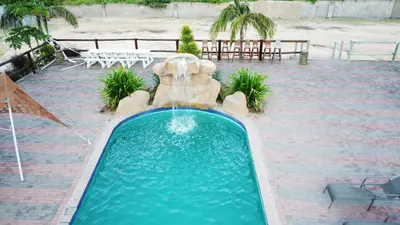 a swimming pool with a water fountain in a patio at Phendulani Lodge & Park in Calcutta