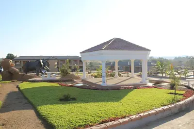 a gazebo in the middle of a garden at Phendulani Lodge & Park in Calcutta