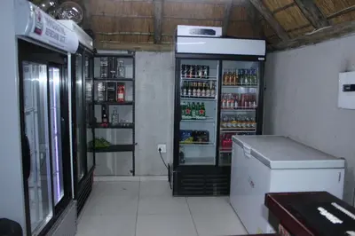 a kitchen with a refrigerator with drinks in it at Phendulani Lodge & Park in Calcutta