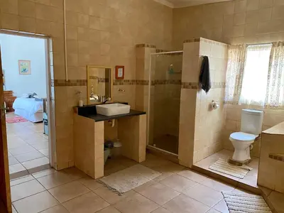 a bathroom with a shower and a sink and a toilet at La Bella B&B Under The Fig Tree in Bela-Bela